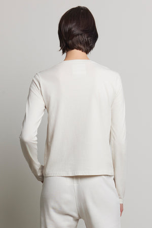 A short-haired person wears the Velvet by Jenny Graham VICENTE TEE and organic cotton pants, with back to camera against a plain backdrop.