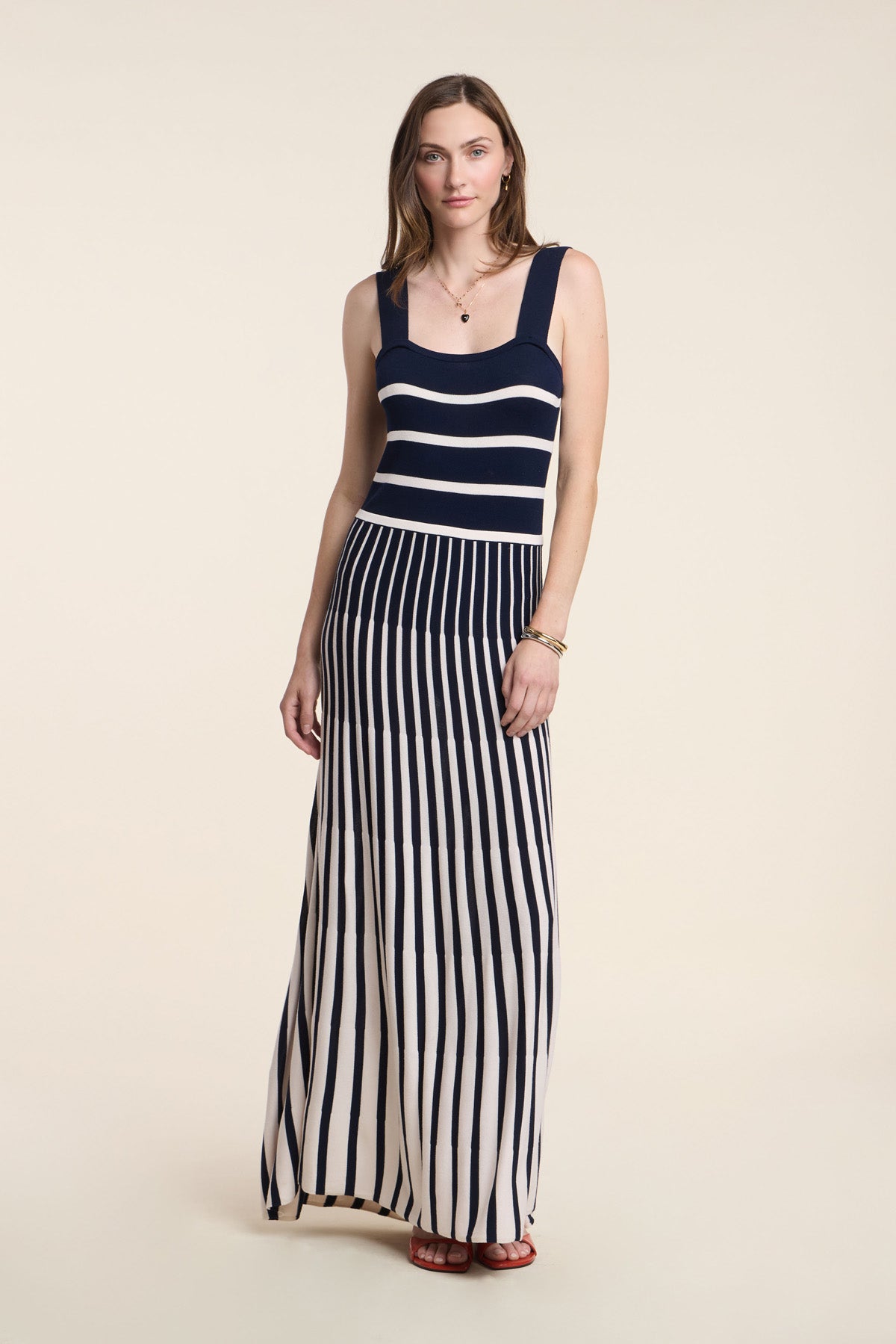A woman models the AVELINE DRESS by Velvet by Graham & Spencer, a sleeveless maxi with a fitted bodice and navy and white stripes, standing against a plain light background.-41526920478913