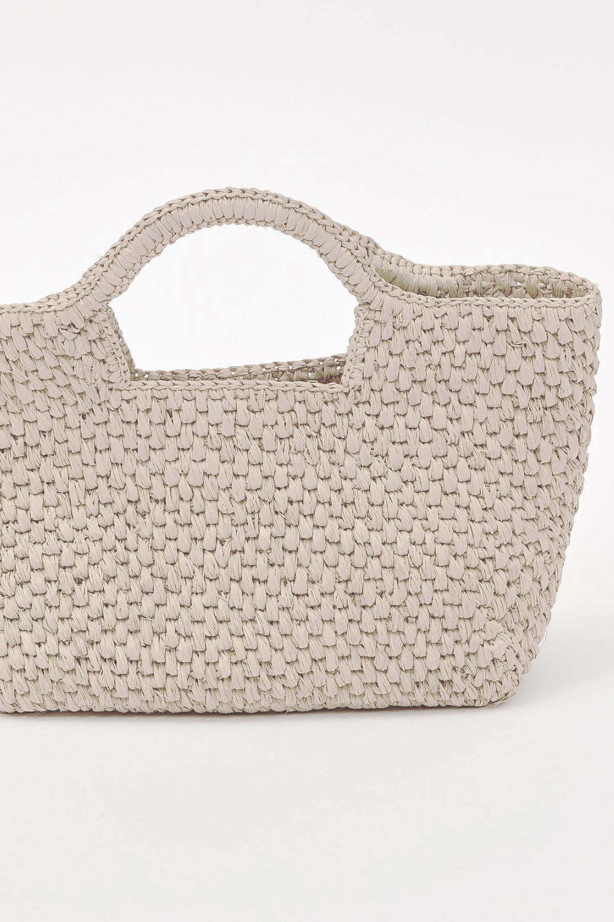 The SANDY BAG by Velvet by Graham & Spencer is a handcrafted beige raffia basket tote with short handles, shown against a plain white background—a stylish warm-weather essential.-41491458588865