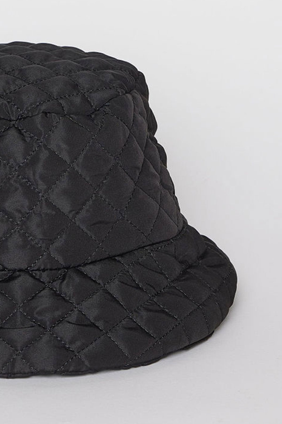 Close-up of the MODERN QUILTED BUCKET HAT in black by Velvet by Graham & Spencer on a neutral background.-38485968224449