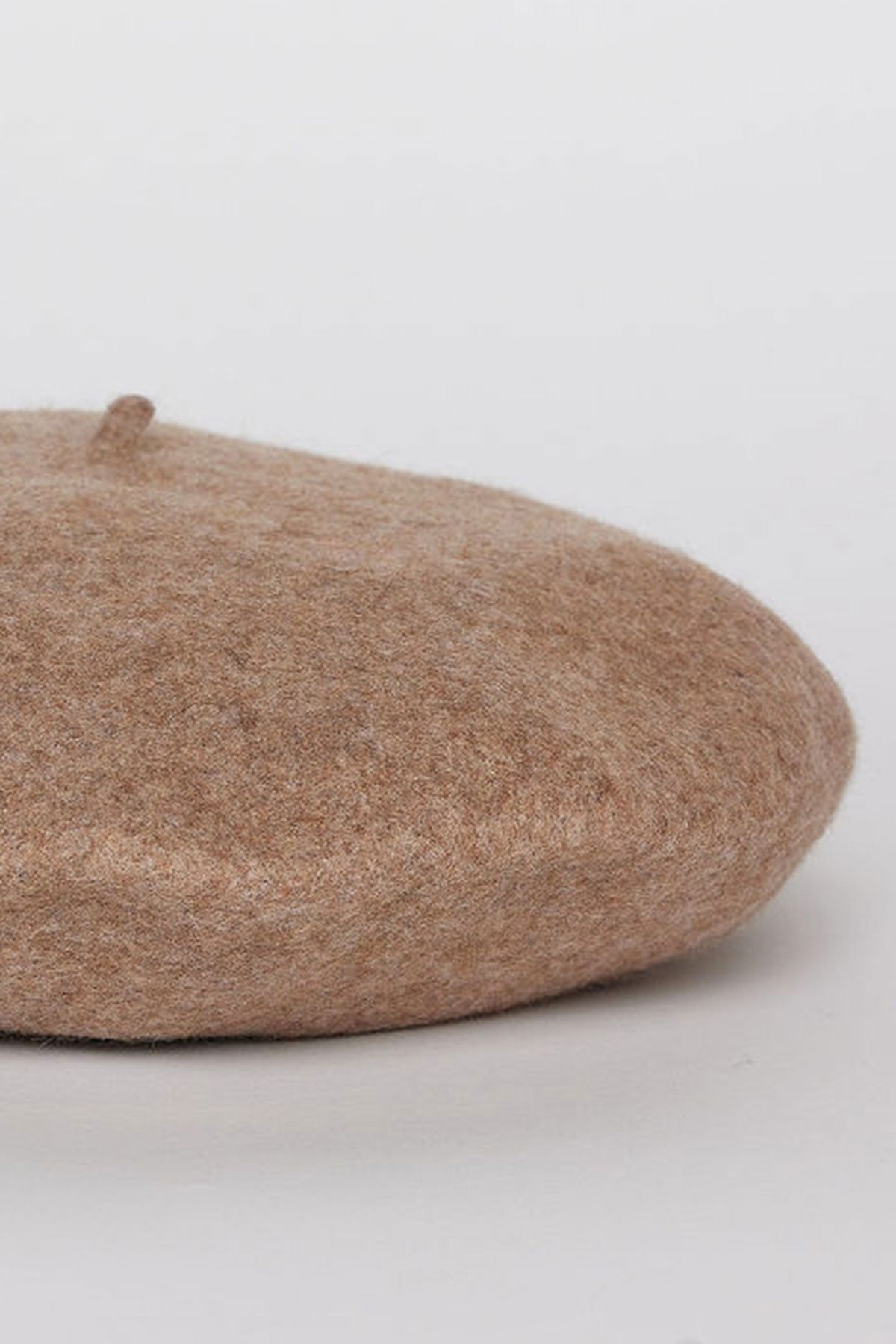A CLASSIC BERET by Velvet by Graham & Spencer, crafted from wool in a beige hue, is placed on a white background.