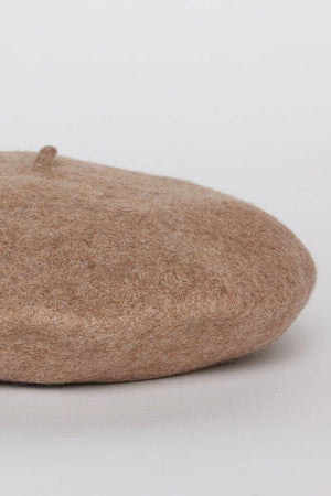A CLASSIC BERET by Velvet by Graham & Spencer, crafted from wool in a beige hue, is placed on a white background.