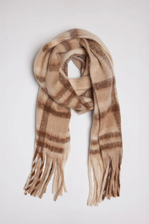 The COZY PLAID SCARF by Velvet by Graham & Spencer is a soft, beige scarf adorned with a brown and tan plaid pattern and finished with fringed edges.
