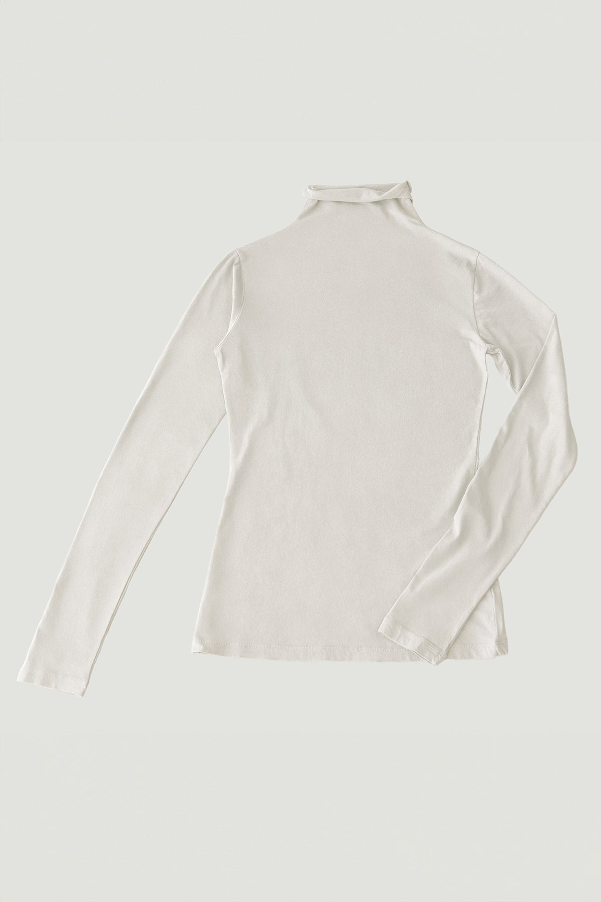 Image of the Velvet by Graham & Spencer TALISIA TEE, a long-sleeved, cream-colored turtleneck shirt laid flat on a light background, showcasing its fashion-forward appeal and the versatility it adds to any wardrobe.