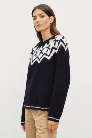 A woman wearing a navy ALEXA FAIR ISLE CREW NECK SWEATER by Velvet by Graham & Spencer.