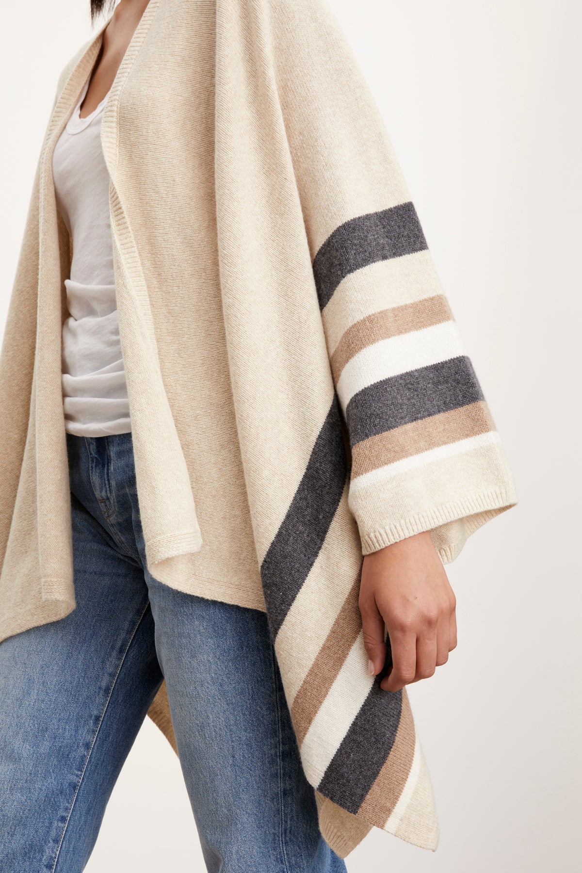 A woman wearing a Velvet by Graham & Spencer Harper Open Front Poncho in beige and tan stripes.-26897793056961