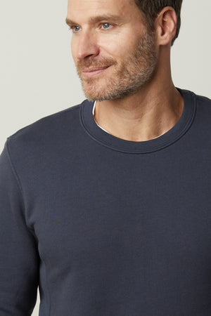 A man donning a Velvet by Graham & Spencer KING CREW NECK SWEATSHIRT for his everyday look.