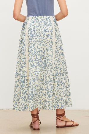 The back view of a woman wearing a Velvet by Graham & Spencer KONA FLORAL LACE MAXI SKIRT with an elastic waist.