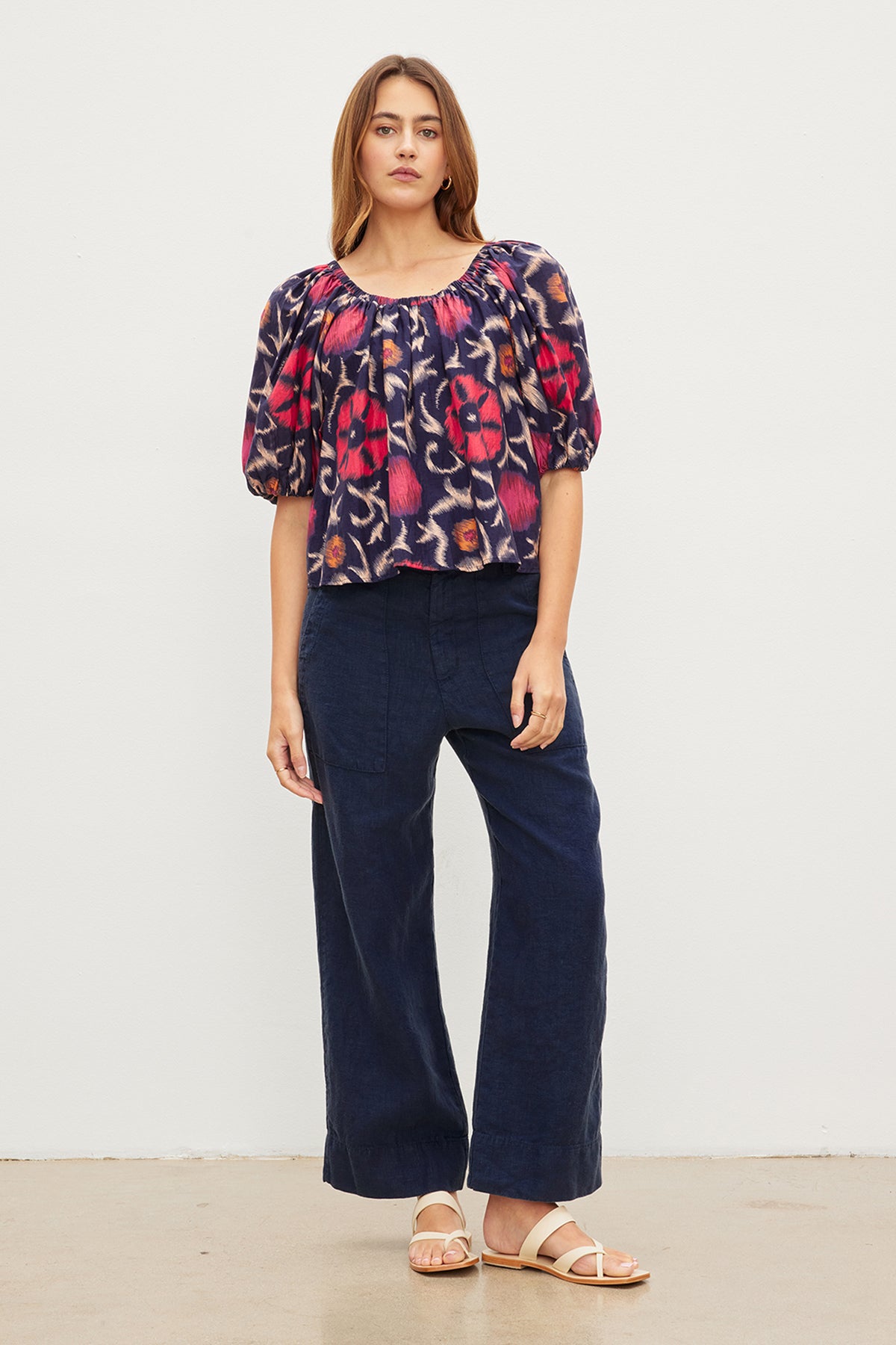 The stylish model is wearing a cool Velvet by Graham & Spencer navy floral top and wide leg pants.