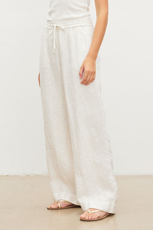 A woman wearing Gwyneth heavy linen pants by Velvet by Graham & Spencer with a relaxed drape and a white t-shirt.
