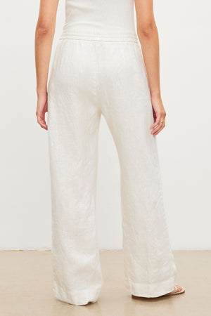 The back view of a woman wearing GWYNETH HEAVY LINEN PANT by Velvet by Graham & Spencer with a relaxed drape.