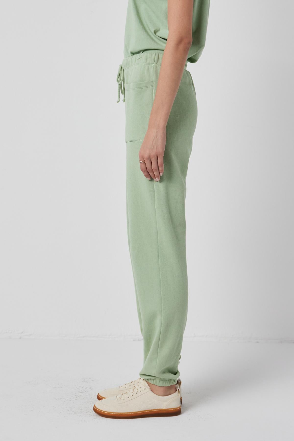   The model is wearing a green Westlake Sweatpant and a white tee by Velvet by Jenny Graham. 
