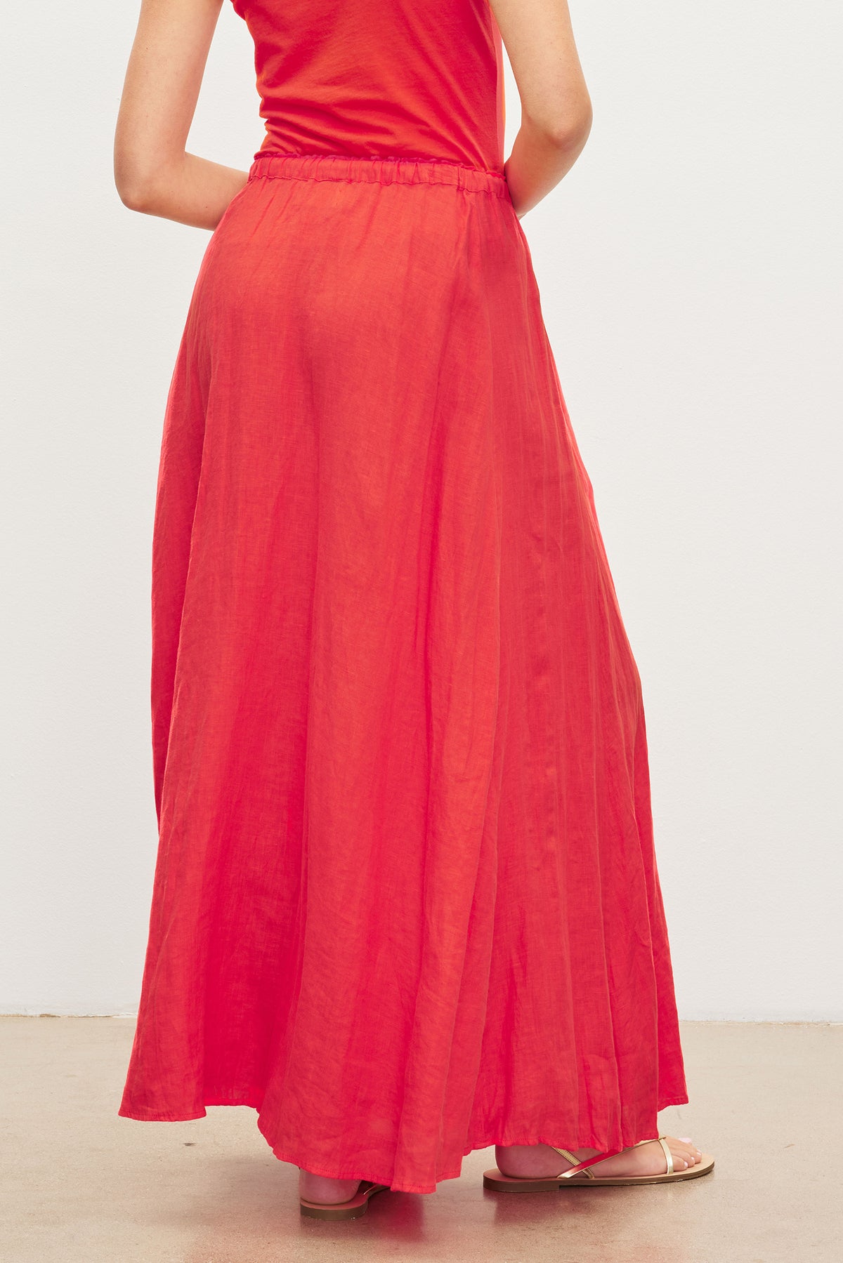 The woman is wearing a red Velvet by Graham & Spencer Bailey Linen Maxi Skirt.