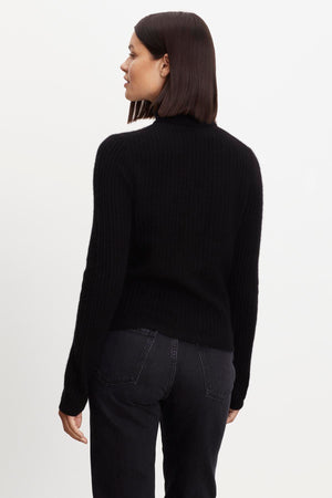 A woman in a Velvet by Graham & Spencer Lori Cashmere Turtleneck Sweater.