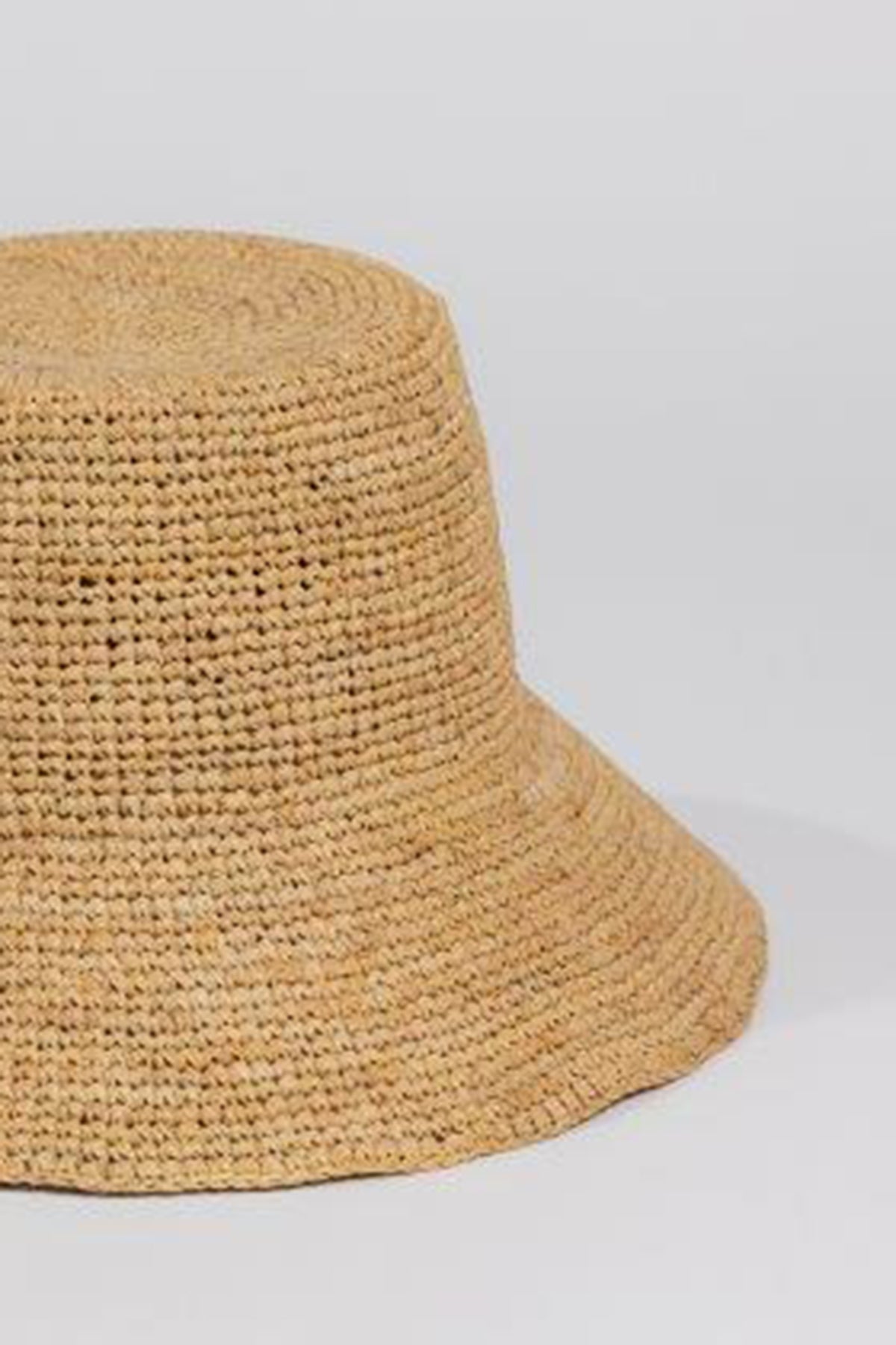 The CHIC CROCHET BUCKET HAT by Velvet by Graham & Spencer, crafted in beige woven raffia, is shown against a light gray background, offering stylish sun protection.-36571469676737