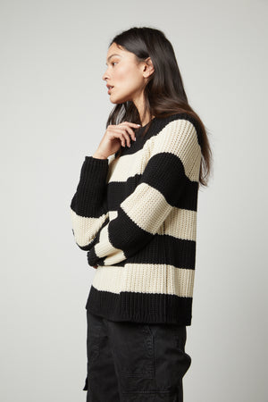 A woman wearing a Velvet by Graham & Spencer CIARA STRIPED CREW NECK SWEATER.