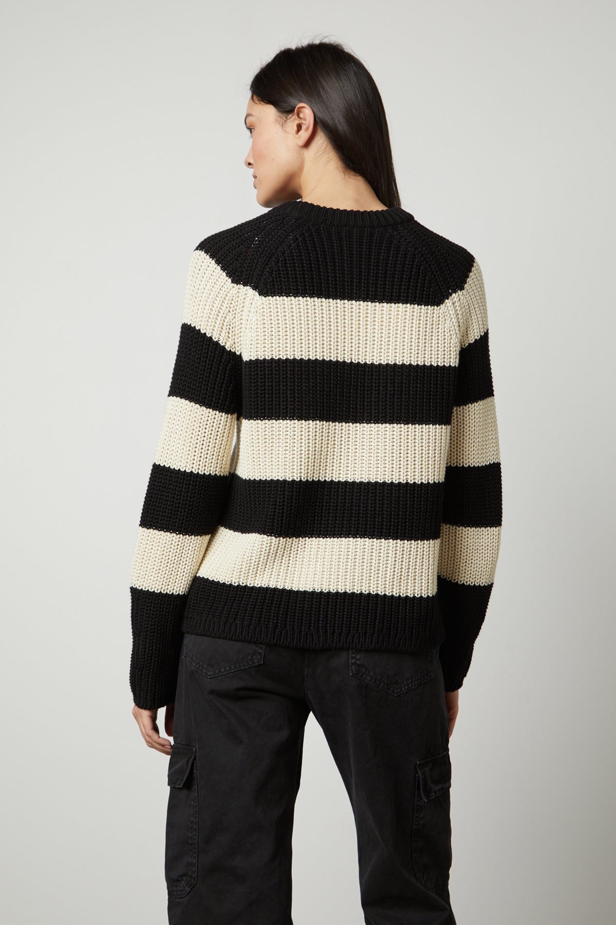The back view of a woman wearing a Velvet by Graham & Spencer CIARA STRIPED CREW NECK SWEATER.