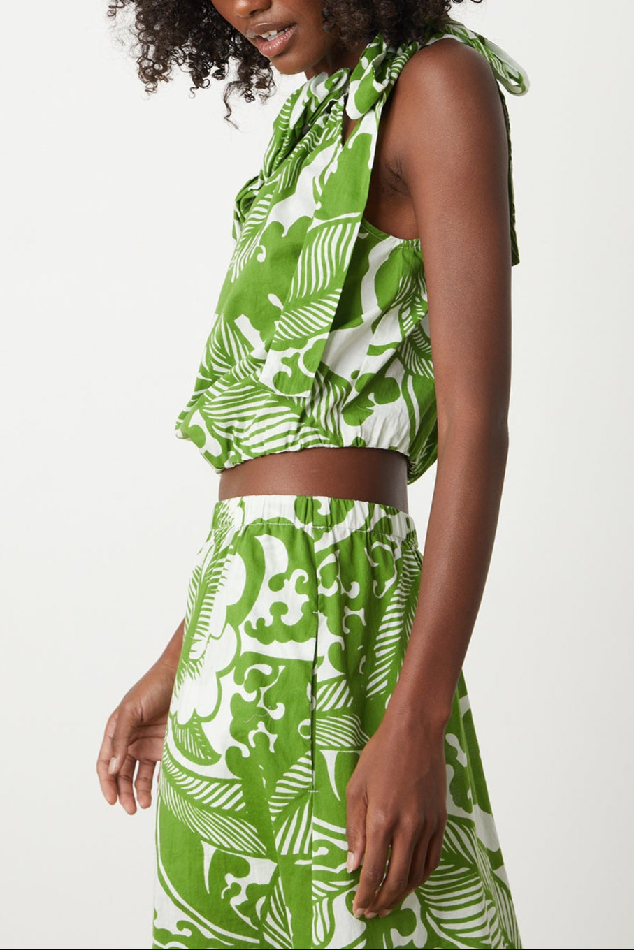 A woman wearing a Velvet by Graham & Spencer CAMILLA PRINTED ONE SHOULDER TOP and shorts.