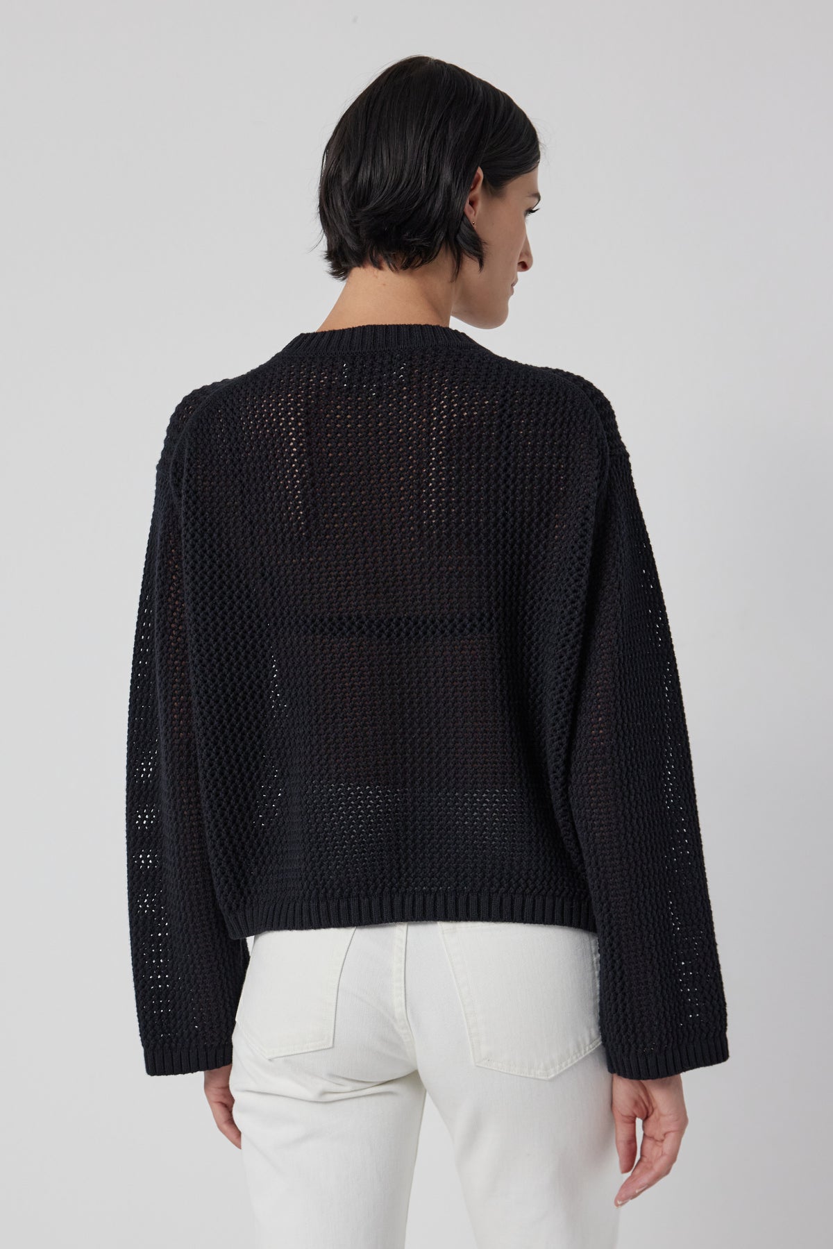   The back view of a woman wearing a lightweight Velvet by Jenny Graham Kanan Sweater and white jeans. 