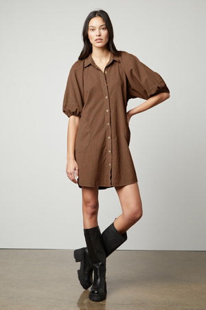 The model is wearing a KADY CORDUROY BUTTON-UP DRESS by Velvet by Graham & Spencer and black boots.