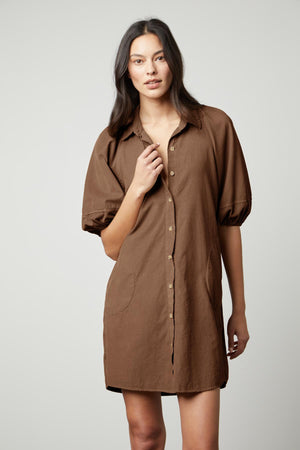 The model is wearing a Velvet by Graham & Spencer KADY CORDUROY BUTTON-UP DRESS.
