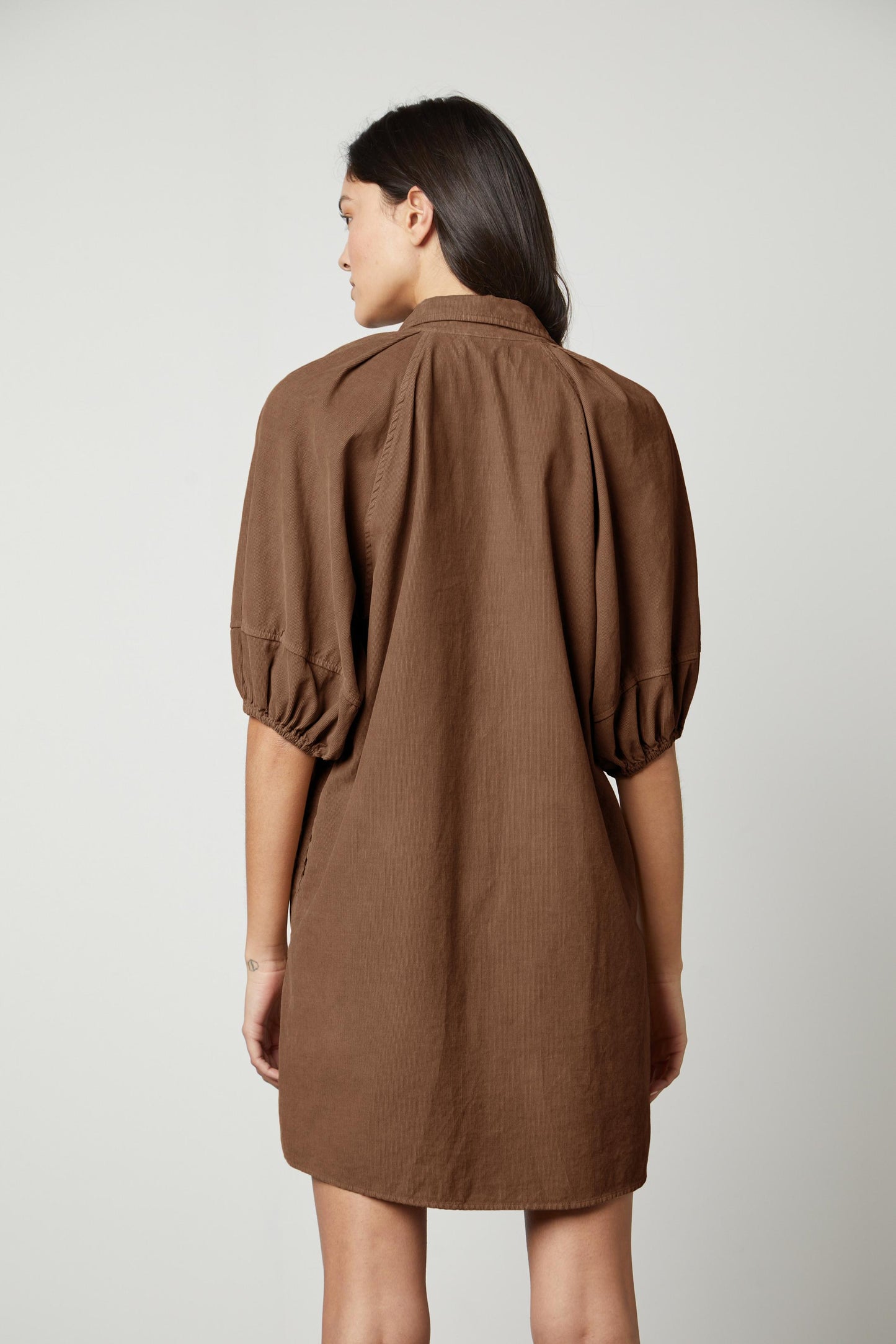 The back view of a woman wearing a Velvet by Graham & Spencer KADY CORDUROY BUTTON-UP DRESS.-26727742243009