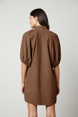 The back view of a woman wearing a Velvet by Graham & Spencer KADY CORDUROY BUTTON-UP DRESS.