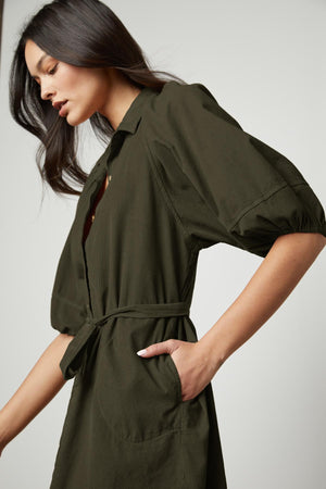 The model is wearing a Velvet by Graham & Spencer KADY CORDUROY BUTTON-UP DRESS with a belt.