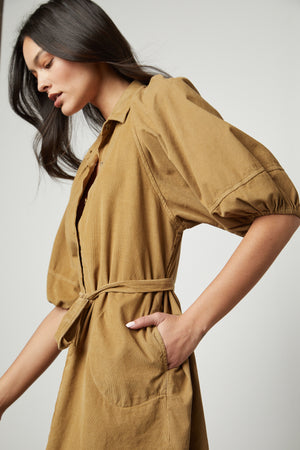 The model is wearing a Velvet by Graham & Spencer KADY CORDUROY BUTTON-UP DRESS.