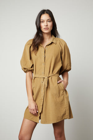 The model is wearing a Velvet by Graham & Spencer KADY CORDUROY BUTTON-UP DRESS.