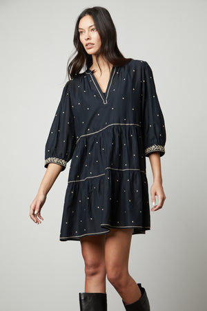 A woman wearing the Velvet by Graham & Spencer KILEY EMBROIDERED BOHO DRESS and black boots.