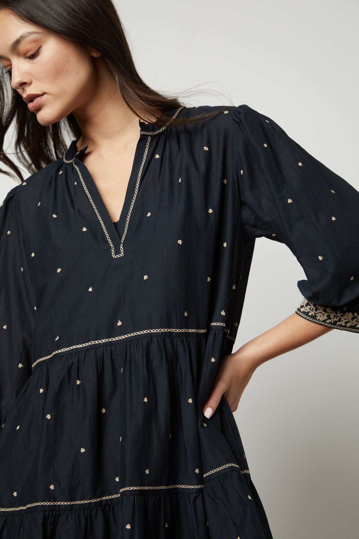 The model is wearing a KILEY EMBROIDERED BOHO DRESS by Velvet by Graham & Spencer with widely spaced gold embroidered dots.-26727746502849