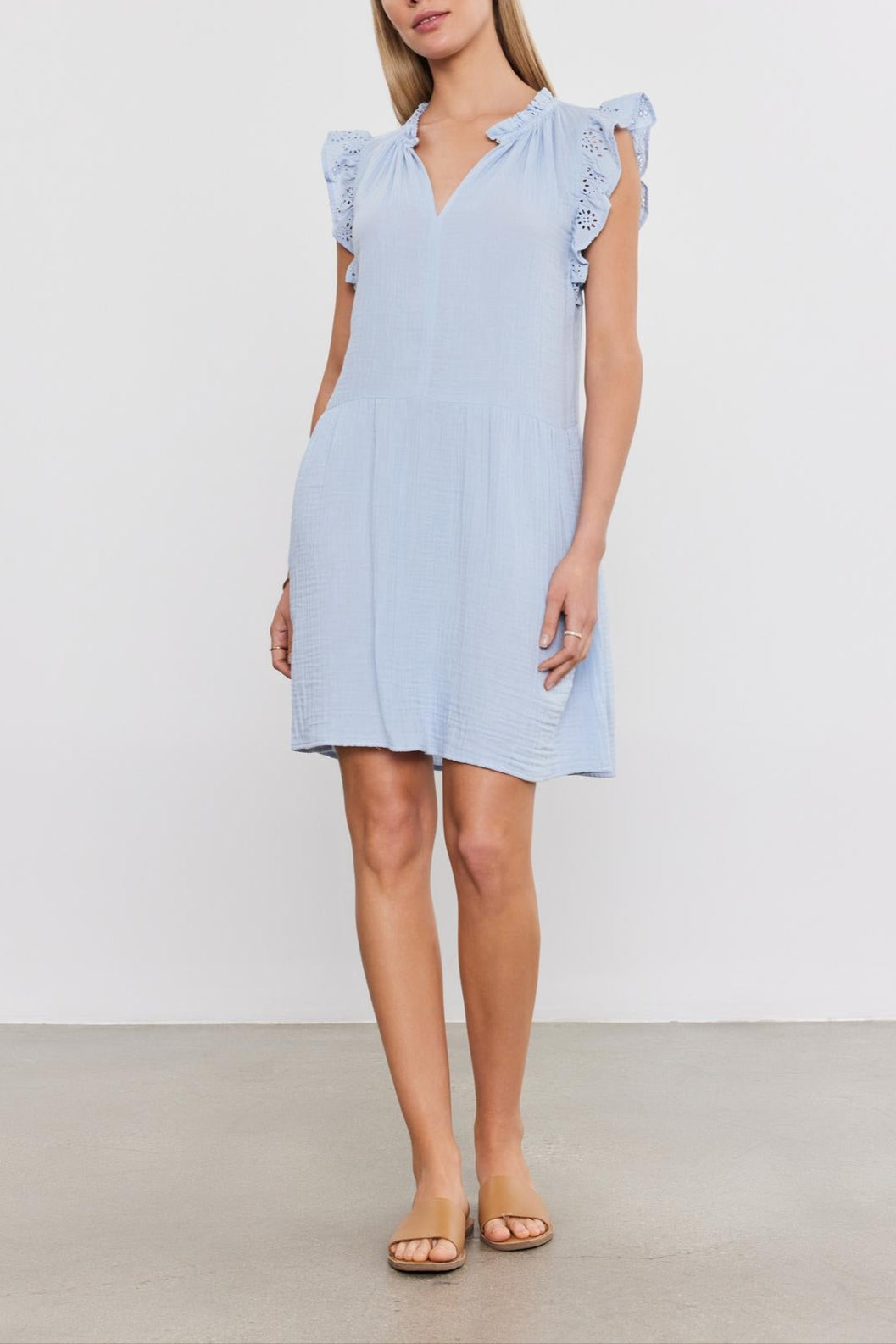 Woman in a Velvet by Graham & Spencer GRACE DRESS with puffy sleeves and sandals, standing against a plain background.
