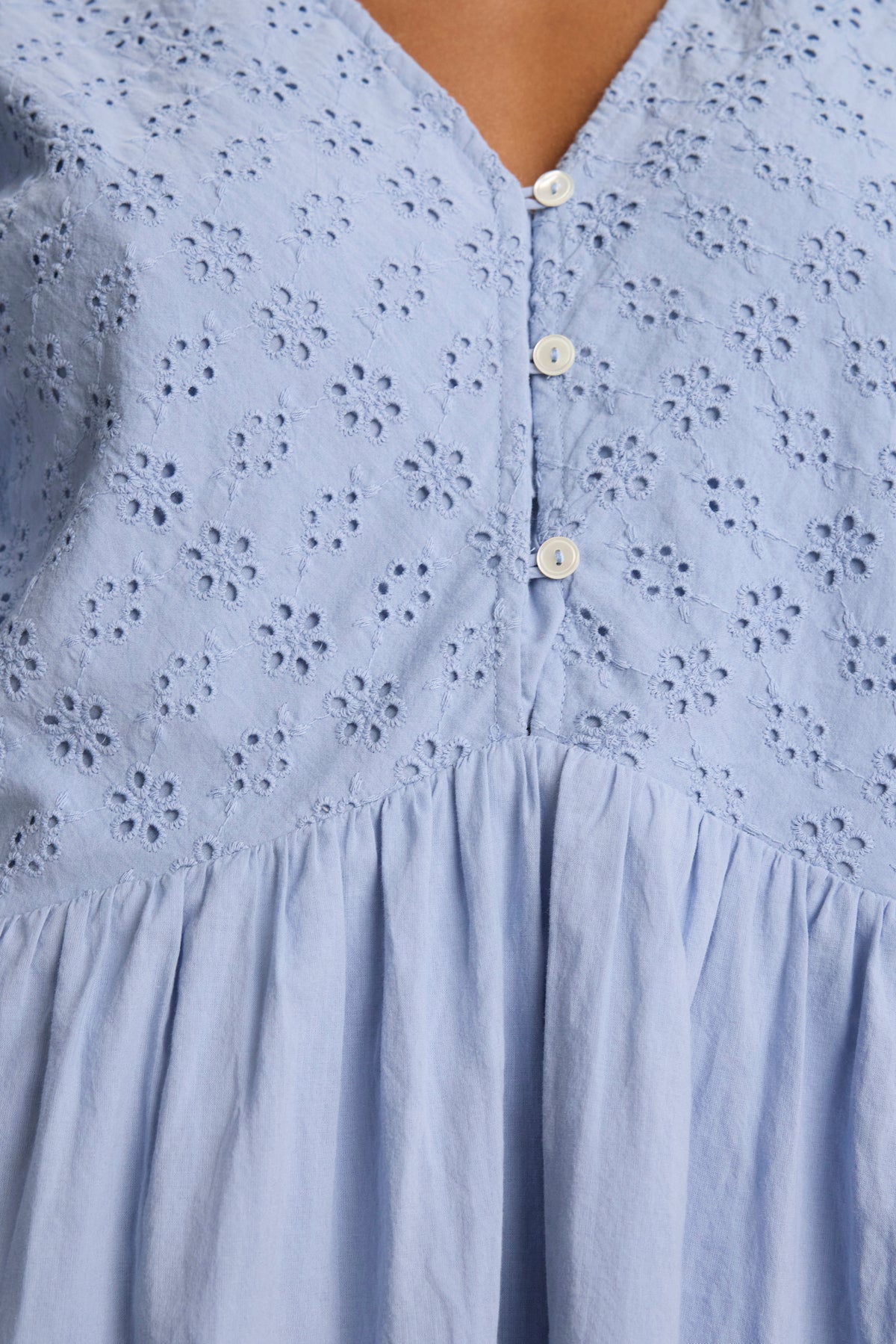 The NELLI EYELET DRESS by Velvet by Graham & Spencer features light blue cotton with eyelet floral embroidery, a V-neckline, three white buttons, short sleeves, and a gathered waist.-39123389022401