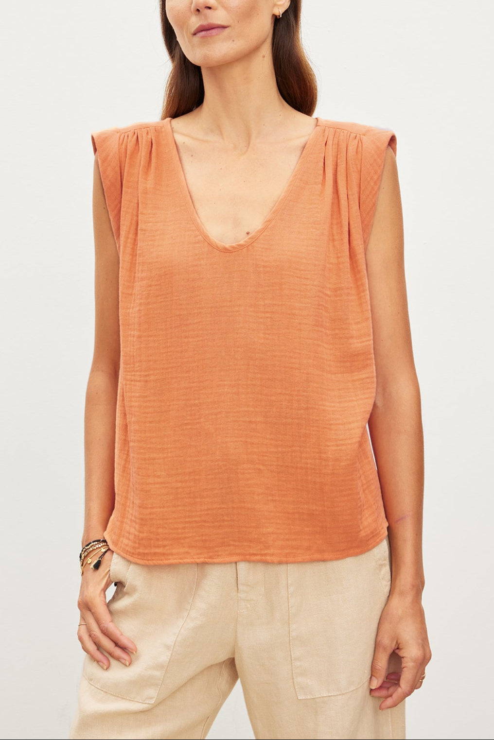 A woman wearing a JAYLA COTTON GAUZE TANK TOP in an orange color by Velvet by Graham & Spencer.-35967557533889