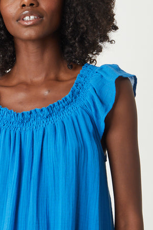 a black woman wearing a Velvet by Graham & Spencer JUSTINE COTTON GAUZE MIDI DRESS with ruffles.