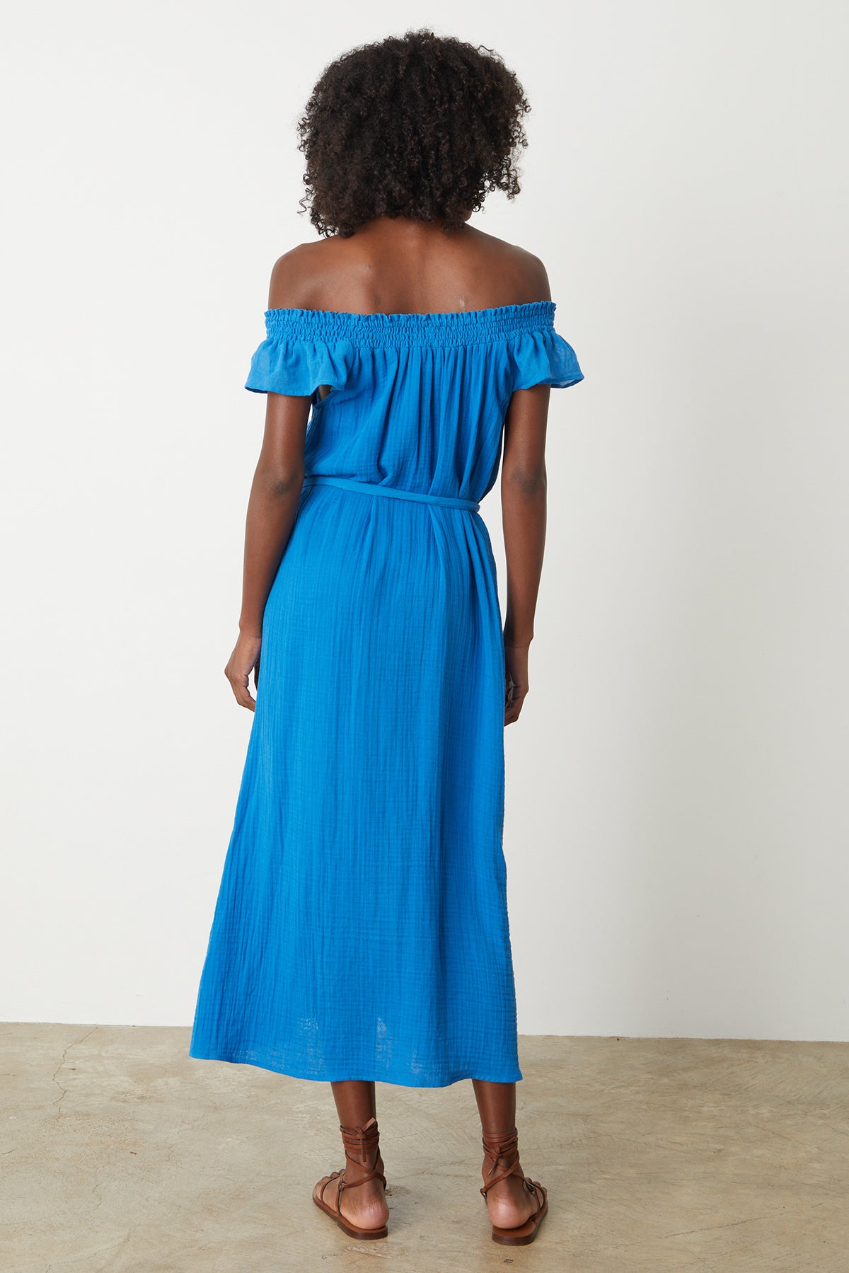 The back view of a woman wearing a Velvet by Graham & Spencer JUSTINE COTTON GAUZE MIDI DRESS.-26342713000129