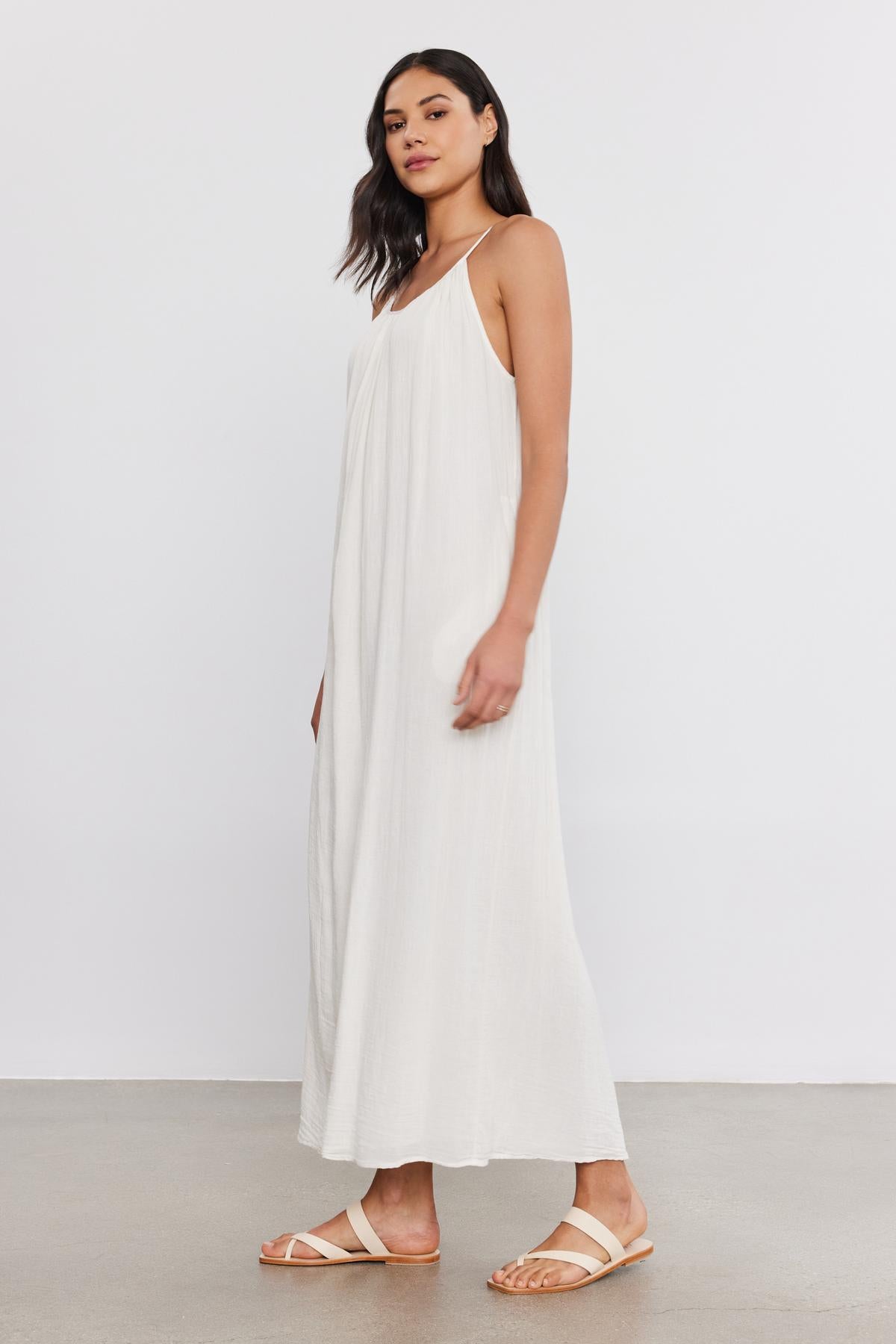 A woman wearing the LORELEI COTTON GAUZE DRESS from Velvet by Graham & Spencer and sandals, standing against a plain white background.-37934972797121