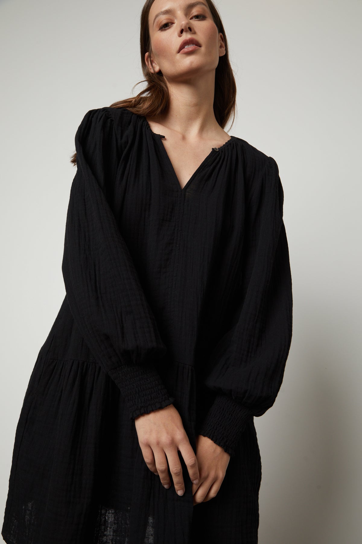 The model is wearing a Velvet by Graham & Spencer VIVIANA COTTON GAUZE DRESS with ruffled sleeves.-35656147206337