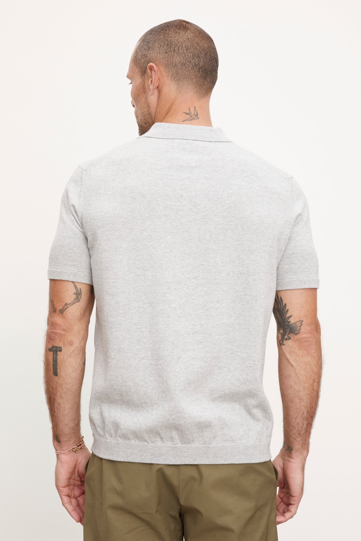 The back view of a man wearing a Velvet by Graham & Spencer OTTO ZIP POLO grey polo shirt.