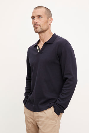 A man wearing a Velvet by Graham & Spencer navy RICO polo shirt and khaki pants.