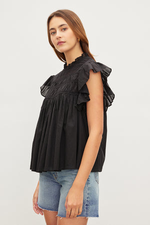 The model is wearing an INESSA COTTON LACE TOP by Velvet by Graham & Spencer with ruffled sleeves.