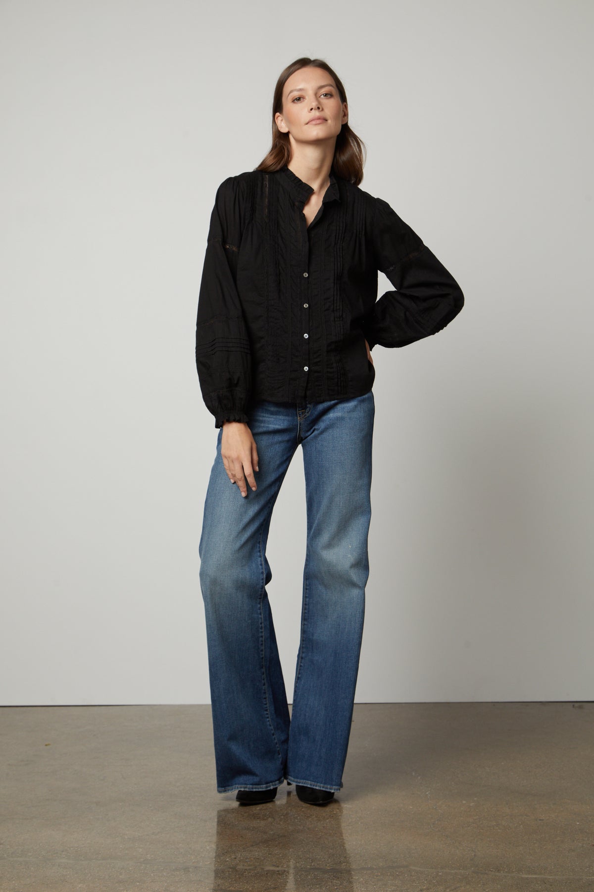 The model is wearing a Velvet by Graham & Spencer Romy Lace Boho Top and flared jeans.-26834995675329