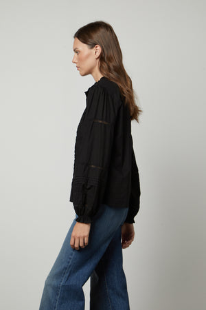 The model is wearing the ROMY LACE BOHO TOP by Velvet by Graham & Spencer.