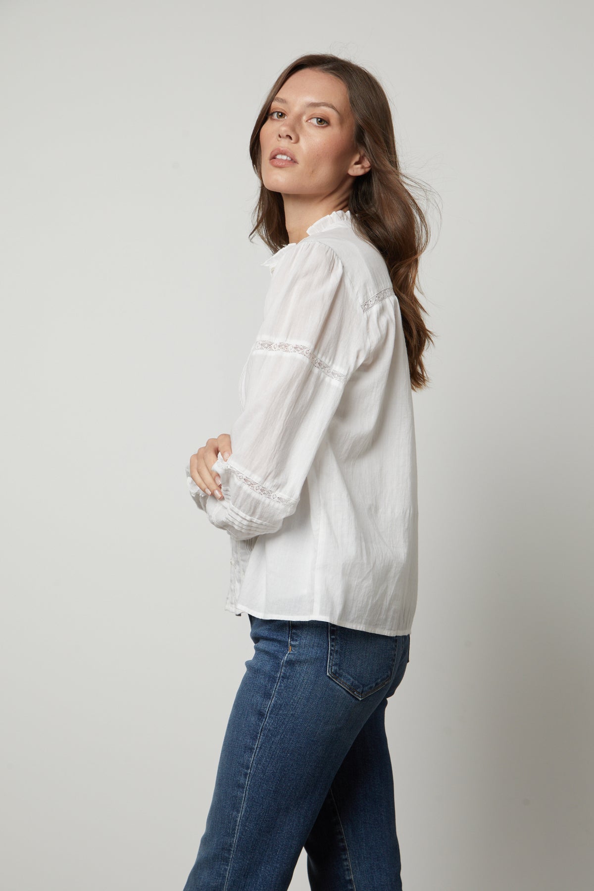 The model is wearing a Velvet by Graham & Spencer ROMY LACE BOHO TOP and jeans.-26834995511489