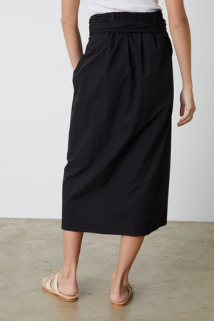 The back view of a person wearing Velvet by Graham & Spencer's LEENA TIE FRONT SKIRT.