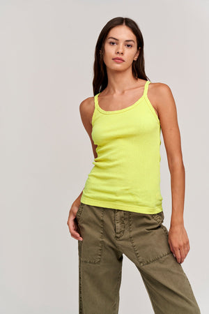 A woman wearing the Velvet by Graham & Spencer ALIZA RIBBED COTTON LAYERING TANK and green pants.