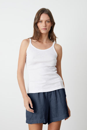 A woman wearing the Velvet by Graham & Spencer ALIZA RIBBED COTTON LAYERING TANK in white and navy shorts.