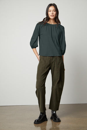 The model is wearing olive trousers and a Velvet by Graham & Spencer JULIE 3/4 SLEEVE TEE.