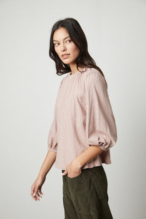 The model is wearing a Velvet by Graham & Spencer JULIE 3/4 SLEEVE TEE with a ruffled sleeve.